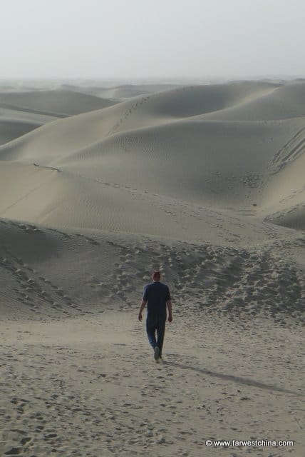 Walking in the Sand A small figure walks through endless Taklamakan desert sands