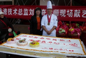 A Bakery owner shows off a huge cake on opening day