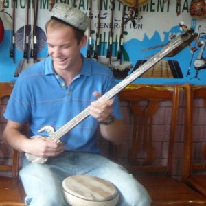 A picture of Josh playing a Uyghur instrument