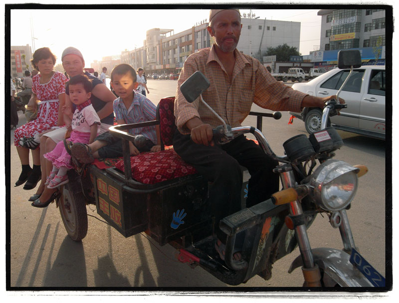 Kuqa Taxi A family rides a motorcycle taxi in Kuqa, Xinjiang