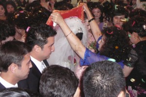 The grooms mother lifts the bride's veil at a Uyghur wedding