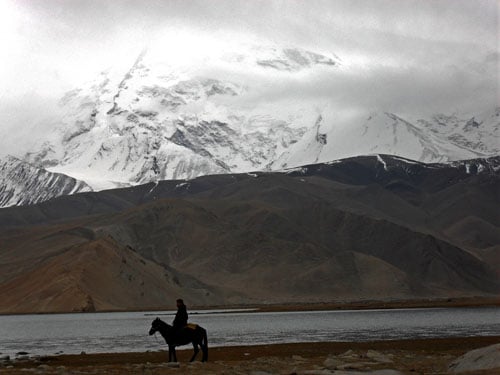 A horse rider next to Karakul Lake