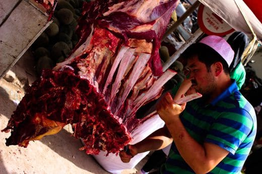A butcher fixes meat in Kashgar's Sunday Market