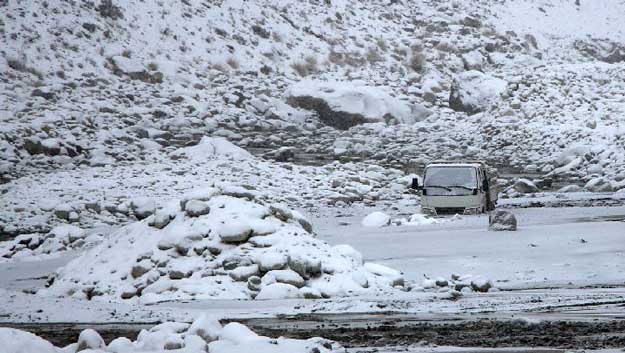 A car sits stranded in a mudslide on Xinjiang's Karakoram Highway
