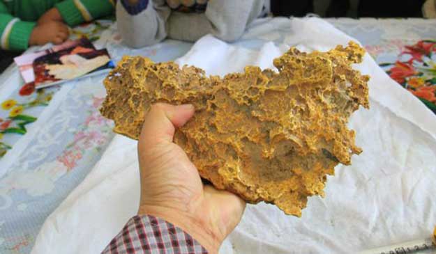 Kazakh herdsman from Xinjiang holds up the gold nugget he found