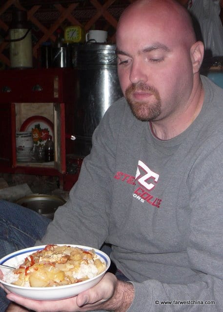 David holds a plate of Kazakh rice, meat and vegetables