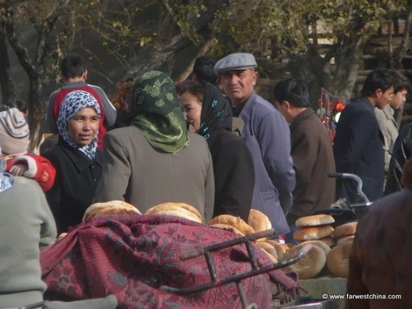 Uyghur people wander around a Friday market in Xinjiang