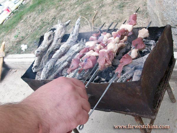 A Uyghur grill kebabs during a BBQ
