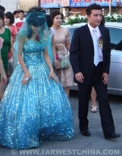 A Uyghur bride and groom walk to their wedding