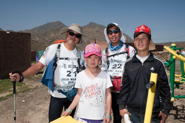 Two local kids learn English from the competitors