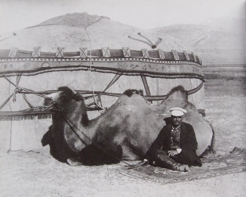 Sven Hedin sits with his camel outside a Xinjiang yurt