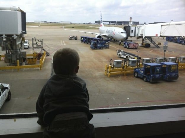 A young boy waits for his flight in an airport