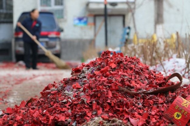 A worker cleans up the mess left behind from Chinese New Year celebrations