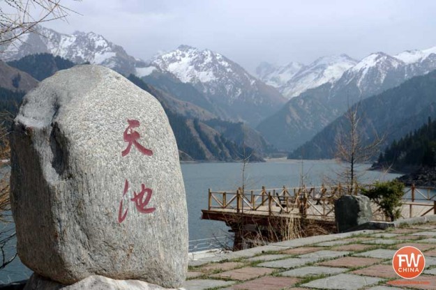 Xinjiang's Heavenly Lake with a stone marker bearing 天池 (the Chinese name)