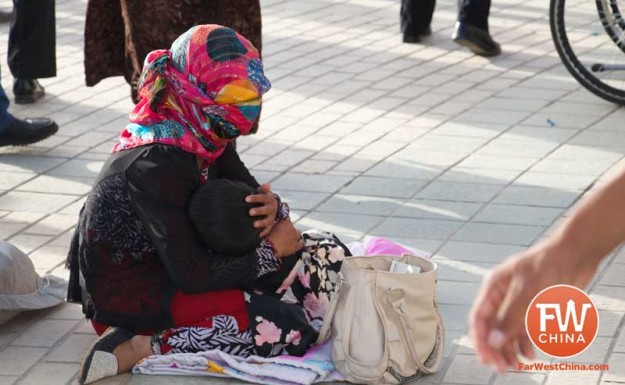 A beggar pleads for charity in front of the Id Kah Mosque in Kashgar, Xinjiang in China