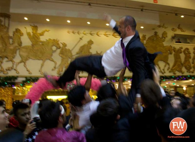 Uyghur groom gets tossed in the air by his men during a Uyghur wedding in Urumqi, Xinjiang