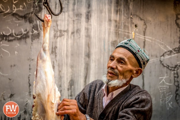 A Uyghur man cuts a sheep carcass in Urumqi, Xinjiang